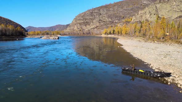 Fisherman Throws a Fishing Rod on the Bank of a Beautiful Wide River Boat Mountain Autumn