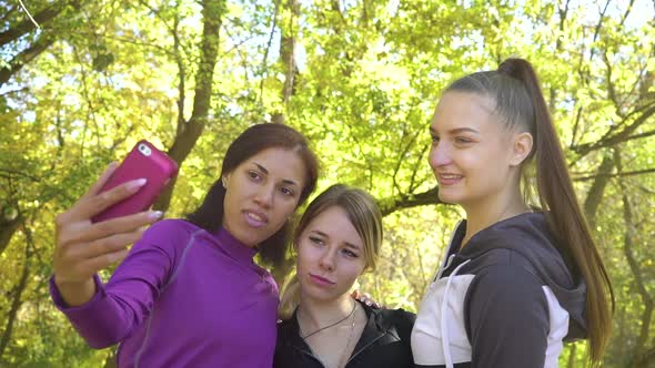 Multiracial Friends in Sportswear Taking Selfie in Autumn Garden alt
