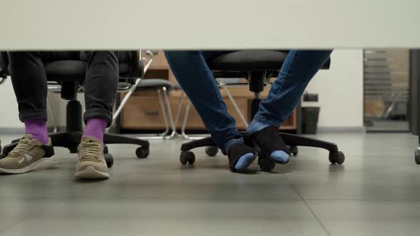 Many people in office cross their legs and put one to another. Unrecognizable persons in socks alt