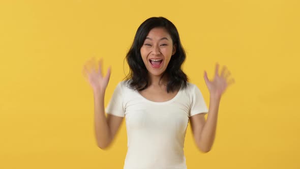 Excited surprised screaming young Asian woman with toothy smile