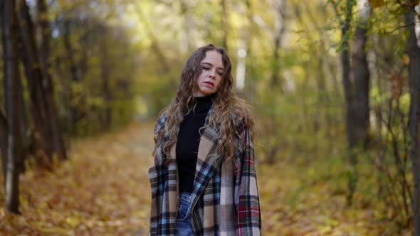 Abandoned Woman is Feeling Sad and Sorrowful Walking Alone in Forest in Fall Day alt