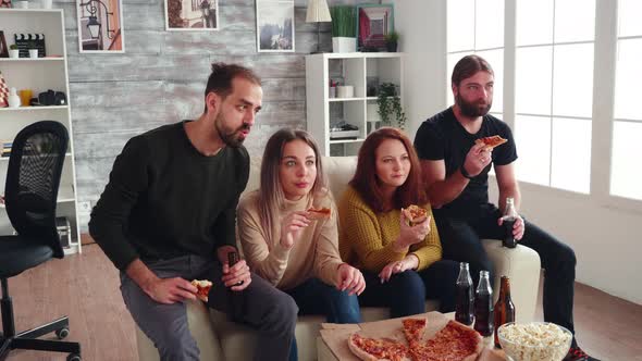 Group of Friends Sitting on Couch Eating Pizza alt
