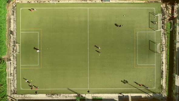Aerial view of people training football in a beautiful football camp. alt