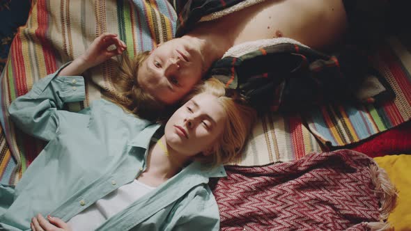 Young Loving Couple Lying on Bed and Looking at Camera alt