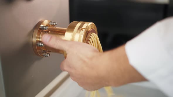 Man Making Fresh Pasta on Traditional Italian Kitchen Machine for Spaghetti Chef Preparing Fresca alt