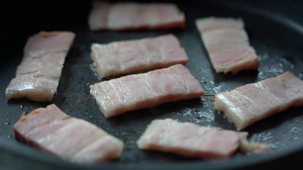 Fry the Bacon Pieces in a Pan. Crispy Pieces of Delicious Bacon Are Fried in a Hot Skillet alt