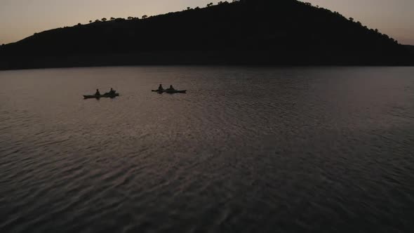 Double canoes sailing through reservoir at sunset alt