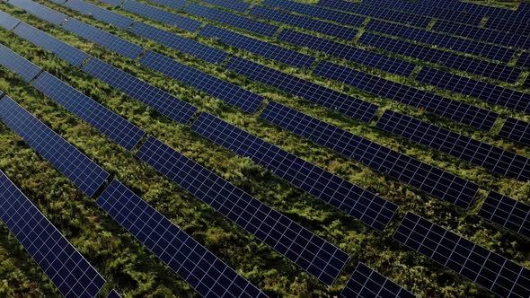 Aerial Top view on Solar Power Station in Green Field on Sunny day. Drone fly over Solar Farm alt