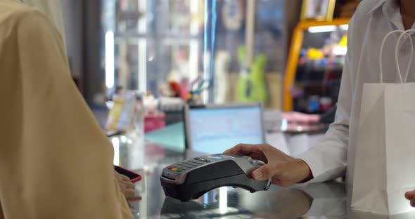 Young woman use smartwatch paying over contactless transactiona at cashier counter 