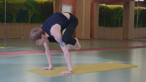 a Young Cute Guy Does a Very Difficult Yoga Asan