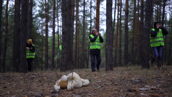 Group of Volunteers in Green Vests Went in Search of Missing Persons in a Pine Forest alt