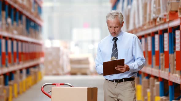 Male warehouse worker checking stock for shipping alt