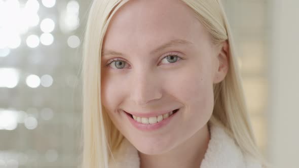 Young Caucasian Woman With Long Blond Hair Wearing a Bath Towel Looking at Camera in a Bright alt