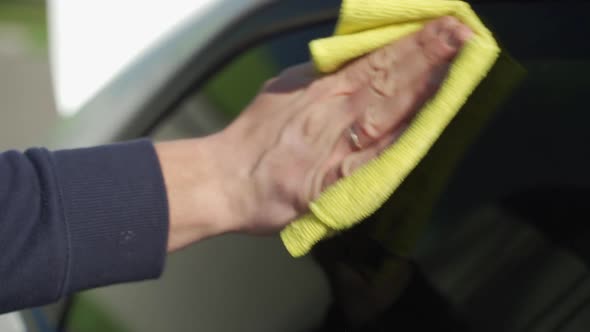 Auto Care Service Staff Cleaning Car Window Glass with Microfiber Cloth alt