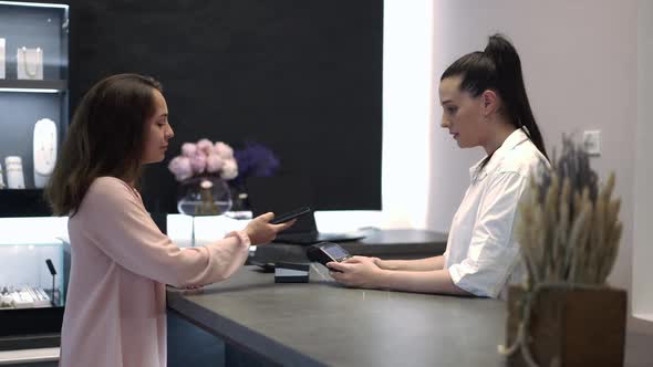 Side View Portrait Young Rich Caucasian Woman Paying with Smartphone for Accessory in Jewellery alt
