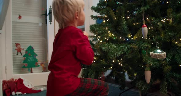 Young Mom with Children Decorate Christmas Tree on Living Room at Evening alt
