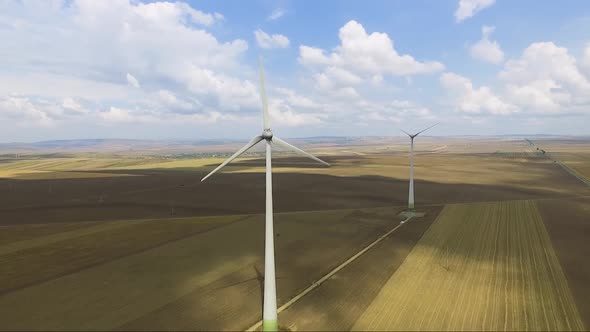 Aerial shot of power generating windmills over agricultural fields