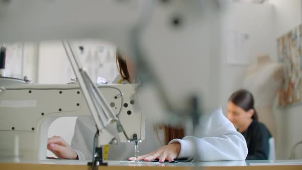 Front View Of Female Fashion Designer Working With Sewing Machine In Workshop alt