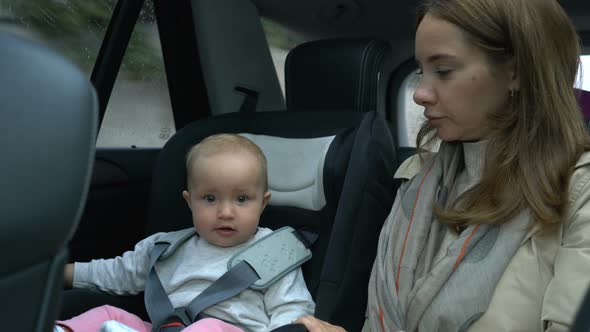 Mom and Baby Girl Ride in the Car in the Back Seat