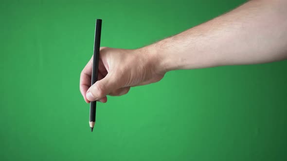 Man Holding Pencil In His Hand Isolated On Chroma Key Green Screen Background alt