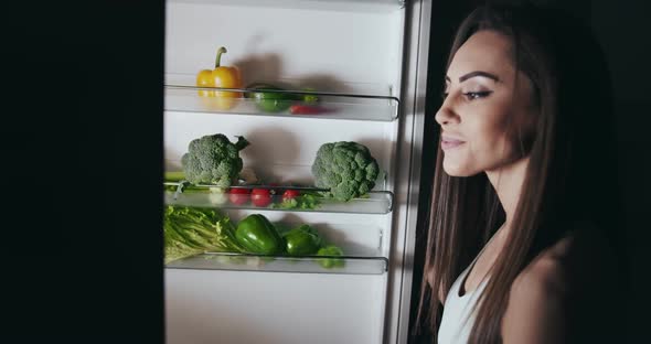 Woman Opening Freezer at Night