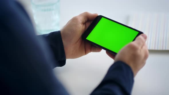 Close Up Man Hands Holding Smartphone with Green Screen. Male Looking Cell Phone alt