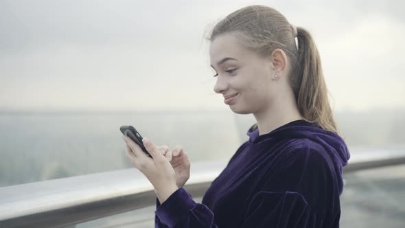 Closeup of Happy Smiling Young Woman Messaging Online Outdoors alt