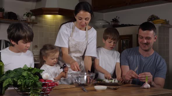 Happy Family with Three Kids is Cooking Salad at Home Together alt