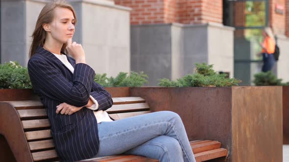 Pensive Business Woman Thinking While Sitting Outside Office on Bench alt