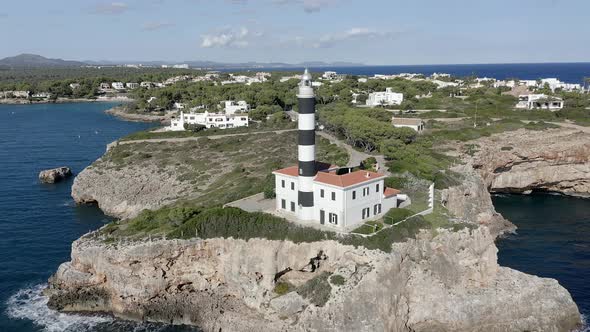 Portocolom lighthouse on rocky cliff at the sea, Mallorca, Spain alt