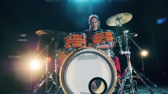 A Musician with Dreadlocks Is Playing Drums. Male Drummer Playing Drums in Smoke alt