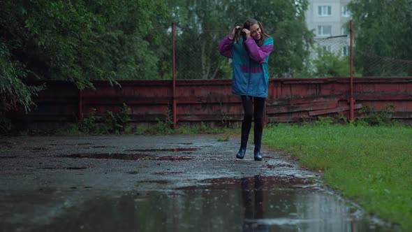 Joyful Happy Girl With Pigtails on Her Head Running Through the Puddles alt