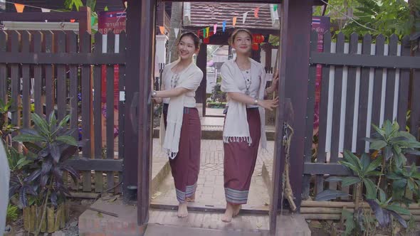 Two Teenage Girls In Thai Traditional Dress Open The Door alt