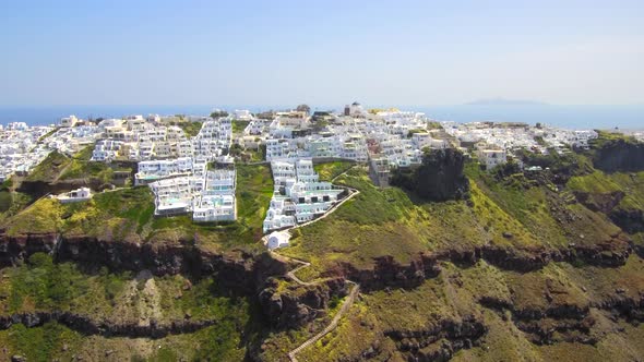 Santorini cliffs with white cave hotels aerial view