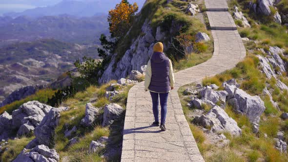 A Young Woman Traveler Visits the View Point on the Top of the Lovcen Mountain alt