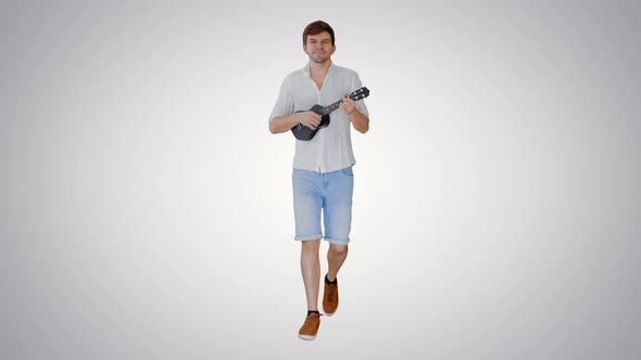 Young Man Playing Ukulele While Walking on Gradient Background alt