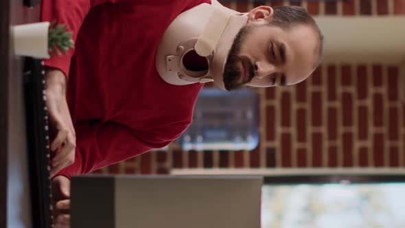 Vertical Video Business Man Using Neck Collar to Recover From Physical Injury alt