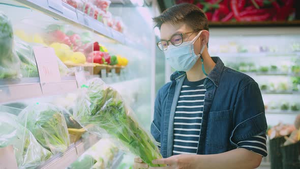 asian male wears medical mask against coronavirus while grocery shopping