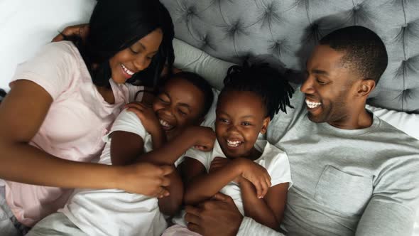 Family having fun together in bedroom 4k alt