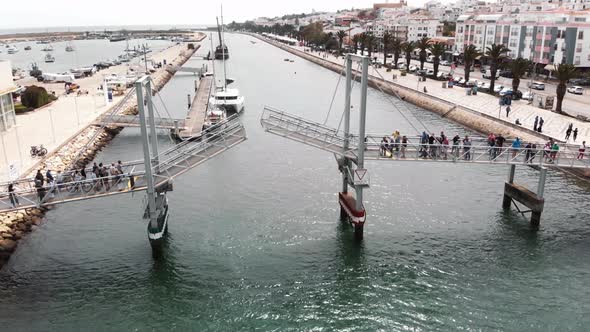 Pedestrian Drawbridge of Marina de Lagos, Faro in Algarve - Low angle Fly-over Aerial alt