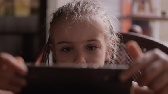 Cute Child Girl Face Portrait Watch Cartoons Via Smart Phone alt