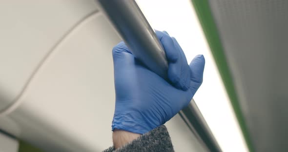 Crop View of Persons Hand in Latex Glove Holding Handrail in Public Transport alt