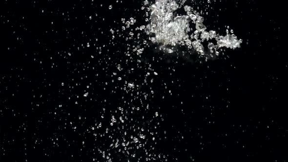 Slow Motion Stream of Water Drops Down in Aquarium on a Black Background alt