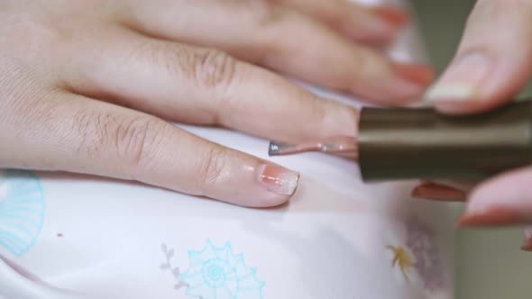 Closeup of a woman paints her nails by self made manicure at home slow motion scene. 4K 25fps alt