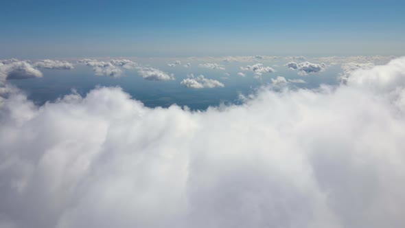 Aerial View From Airplane Window at High Altitude of Earth Covered with White Puffy Cumulus Clouds alt