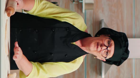 Vertical Video: Old Woman Rolling the Dough at Video Camera alt