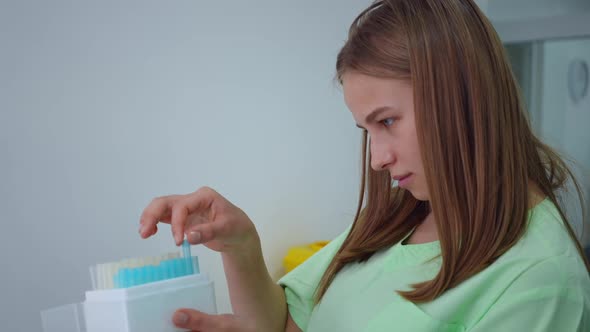 Side View Portrait of Focused Genius Young Female Scientist Checking Test Tubes in Box in Laboratory alt