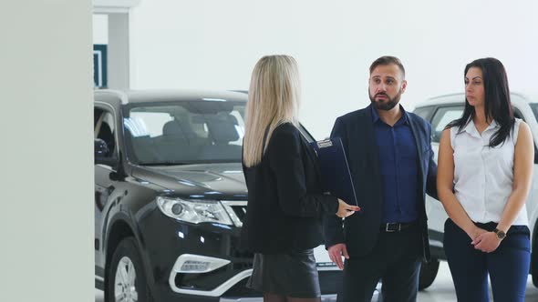Young People Buy a Car and Talk with the Manager of a Trading Hall
