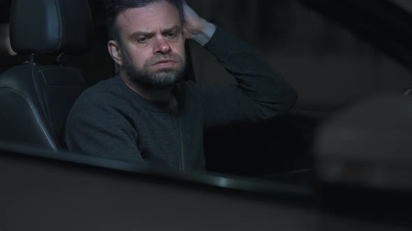 Man Sits in a Car Upset That He Was Stopped By the Police for a Traffic Violation alt