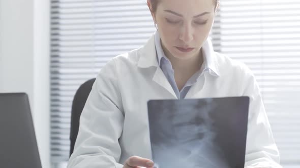 Professional female doctor checking a patient's x-ray